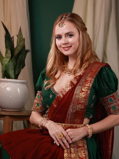 A close-up portrait of Irina Rudakova in traditional attire, smiling warmly. This shot captures the grace and charm required for celebrity portraiture.