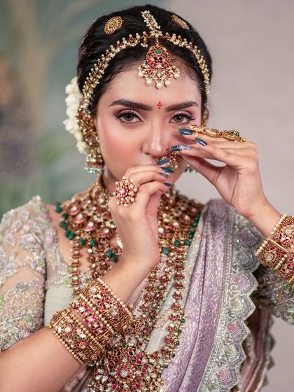 Eyes are silent storytellers. This close-up shot focuses on the bride's expressive eyes, framed by her elaborate jewellery, including the maang tikka and nose ring.