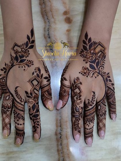 An elegant and modern back-hand design, featuring a flowing vine of leaves and geometric shapes that creates a beautiful open space.