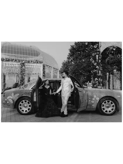 Arriving in style. This black and white shot of the couple with a decorated Rolls Royce adds a touch of classic Hollywood glamour to their reception story.