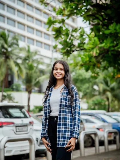 A smiling portrait with a clean, urban background. This is a great example of a simple, effective headshot taken outdoors.
