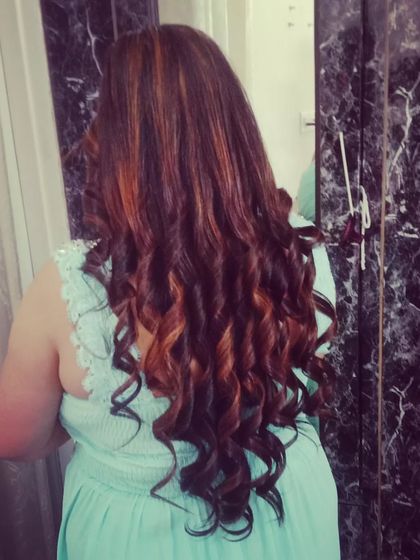 A beautiful example of defined, spiral curls on highlighted hair, creating a look full of texture and dimension.