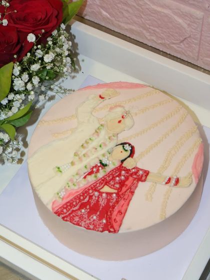 A beautifully crafted wedding-themed cake, showcasing an intricate illustration of a couple during their varmala ceremony.