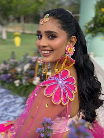 The client smiling, showing off her playful high ponytail and colorful outfit.