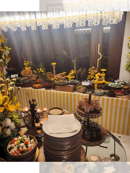 Another view of our yellow-themed buffet, showcasing the full spread under a modern chandelier. The combination of traditional decor and contemporary lighting is stunning.