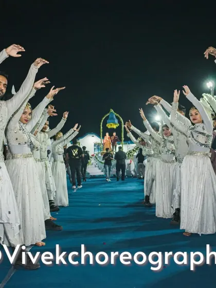 The pathway to a dreamy varmala. Dancers in elegant white costumes create a beautiful formation, welcoming the couple as they proceed towards the main stage.