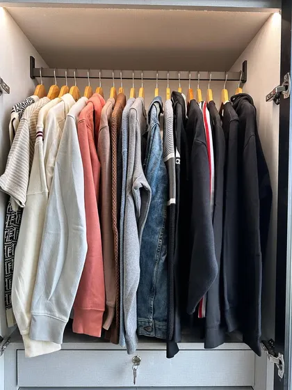 A great tip for optimizing hanging space is to use the same type of hangers. Here, we used broad wooden hangers for heavier items like sweatshirts and jackets.