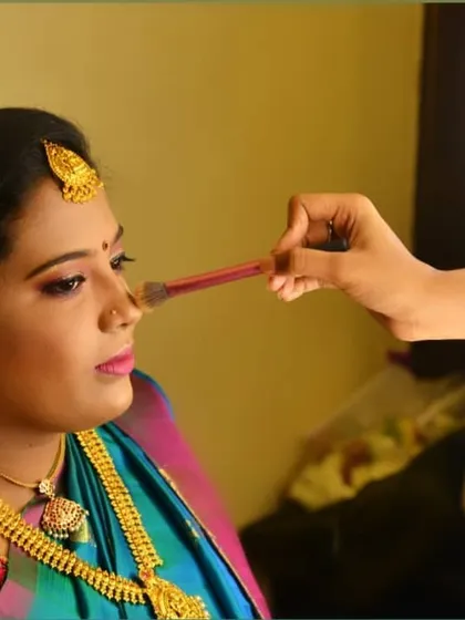 An action shot showing how I work. Using professional brushes and lighting, I am contouring the nose to add definition and ensure the makeup looks flawless from every angle and in all photos.