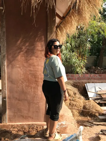 This is me, standing proudly in front of a perfectly plastered cob wall. It’s breathable, non-toxic, and stone-strong, representing the sustainable, healthy lifestyle I advocate for.