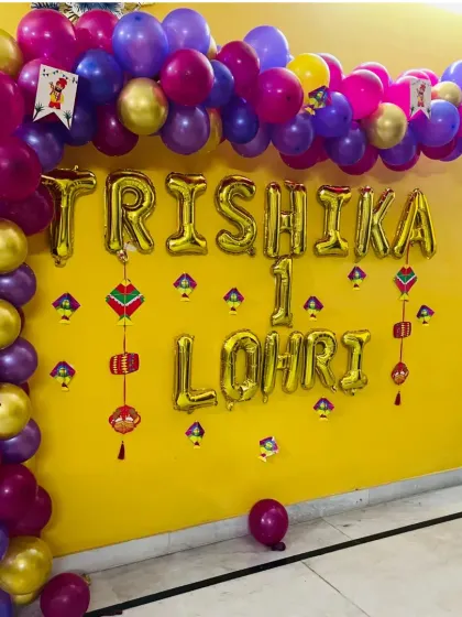 Another view of the balloon arch for Trishika's first Lohri, showing how it frames the wall and creates a festive focal point for a home celebration.