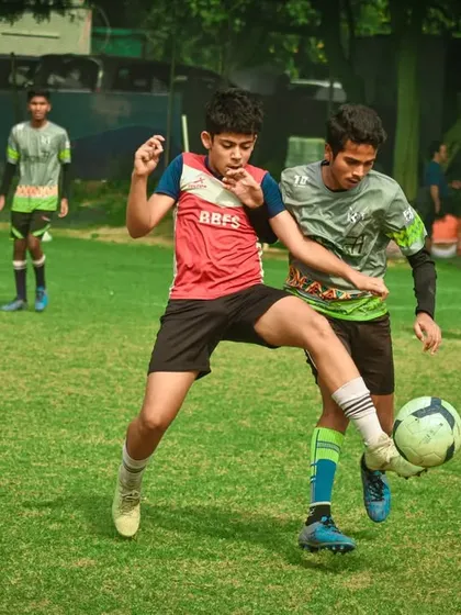A tense moment as two young players vie for the ball, showcasing the competitive edge fostered in our Pride Cup youth matches.
