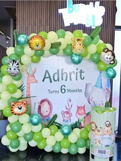 A jungle-themed half-birthday celebration for a 6-month-old, with a custom backdrop and animal foils.
