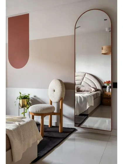 A full shot of the guest bedroom's feature wall, where color blocking and a statement mirror create a simple yet impactful design.