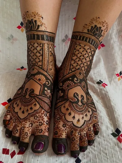 A full view of the bridal feet, matching the hand designs. The swan and lattice patterns create a cohesive and elegant look.