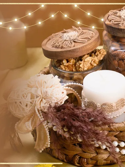 A close-up of one of my rustic Diwali hampers, featuring a woven basket, jars of premium nuts, and a hand-poured candle. It’s all about the warm, cozy details.