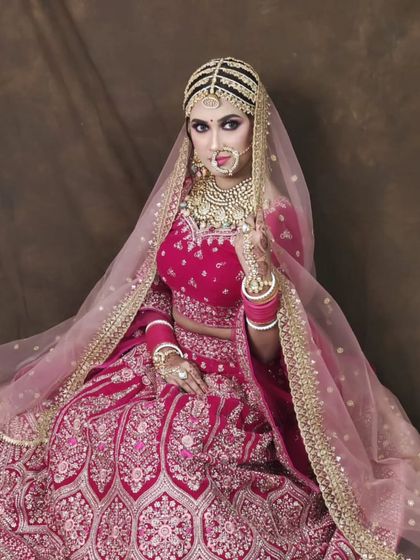 A vibrant pink lehenga with heavy gold embroidery. This is a cheerful and glamorous option for a bride who wants a pop of color.