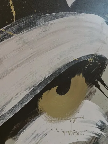 A close-up detail of the abstract painting, showing the fluid movement of the white and gold brushstrokes against the dark background.