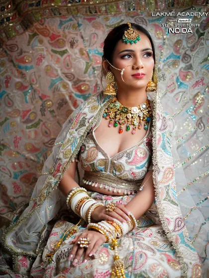 A beautiful portrait of a modern bride. The focus is on the detailed embroidery of her outfit and the way the makeup complements the pastel color palette.