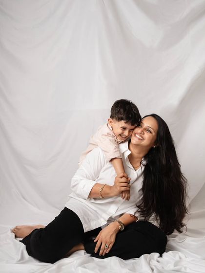 A beautiful, simple portrait of a mother and her son sharing a hug against a clean white backdrop.