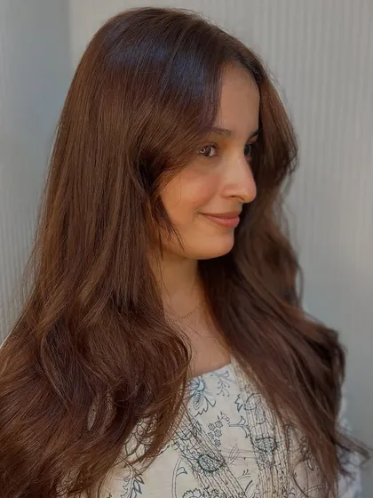 A happy client with her new brown hair. The color is warm and flattering.