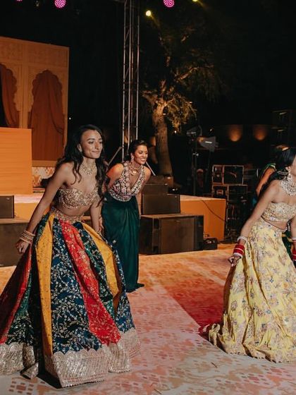 The bridesmaids kicking off the dance performances at the vibrant Mehendi party in the dunes.