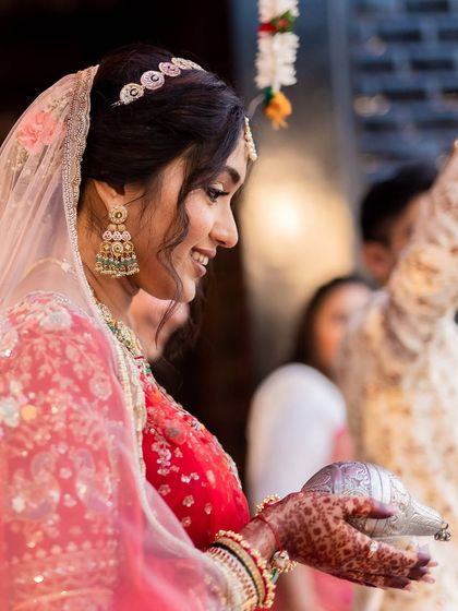The gentle smile of a bride beginning her new journey. Her traditional jhumkas and sheeshpatti add a touch of timeless grace to her look.