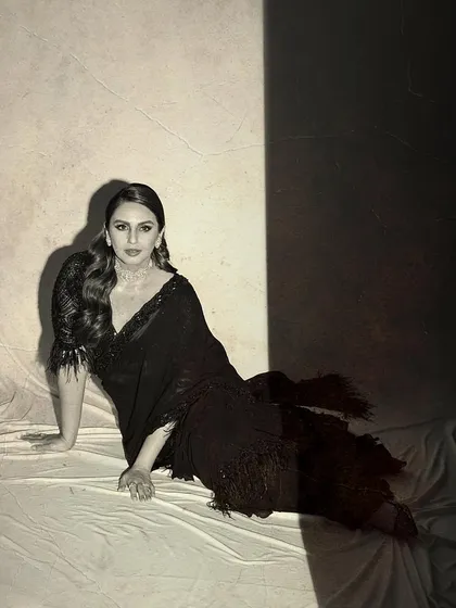 Huma Qureshi channels old-world glamour in this black saree with feather details by Nitika Gujral. The look, styled for the Raj Kapoor 100 event, is a nod to classic Bollywood elegance.