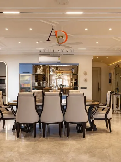 This spacious dining room features a large table, elegant chairs, and a custom crockery unit, all under a beautifully detailed coffered ceiling.