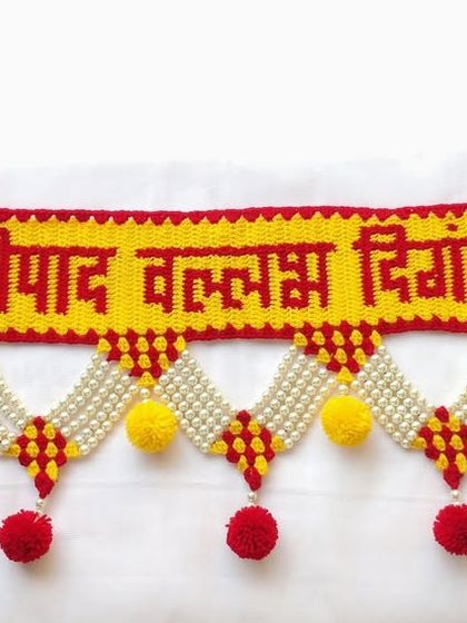 The full "श्रीपाद वल्लभ दिगंबरा" toran, complete with Swastik symbols at both ends for added blessings.