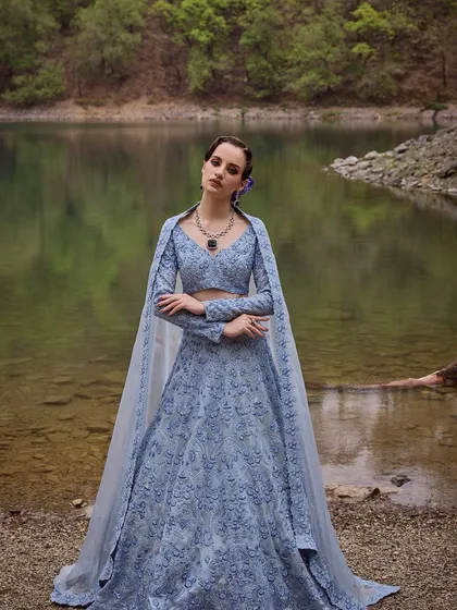 A captivating blue lehenga from the Que Sera Sera collection by Varun Chakkilam. The intricate embroidery and flowing cape create a look that is both mystical and beautiful.