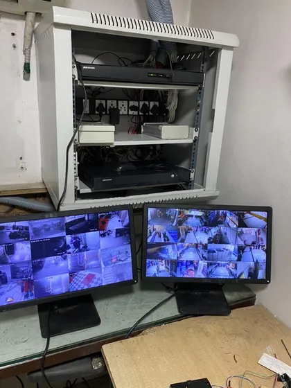 Here is the end result of a professional network and CCTV installation. We organize all essential hardware, including NVRs and network switches, into a clean, wall-mounted server rack, with dual monitors set up for comprehensive security camera monitoring.