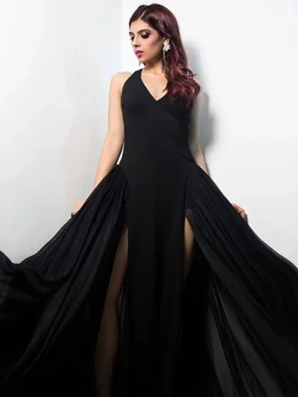 This shot captures the beautiful movement of the black gown. The flowing fabric adds a touch of drama, making it perfect for a red carpet moment or a formal event.