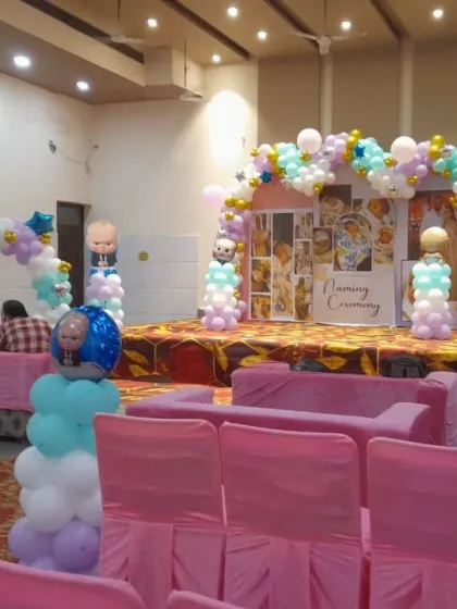 The full view of the naming ceremony hall, with pink seating and Boss Baby themed decorations.
