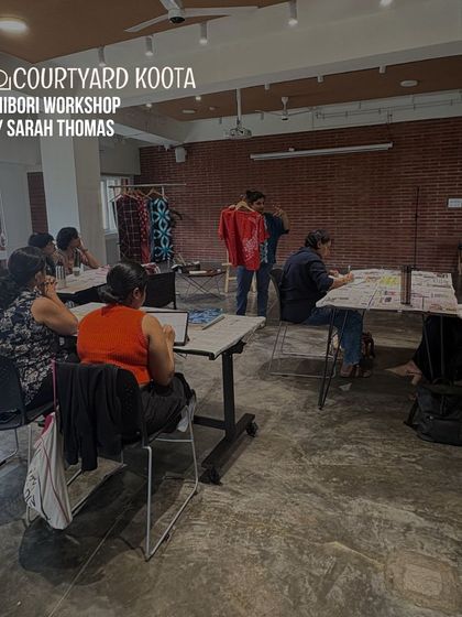 A wide shot of the Shibori workshop in progress. The space is filled with participants focused on their craft, showing the engaging and educational atmosphere.