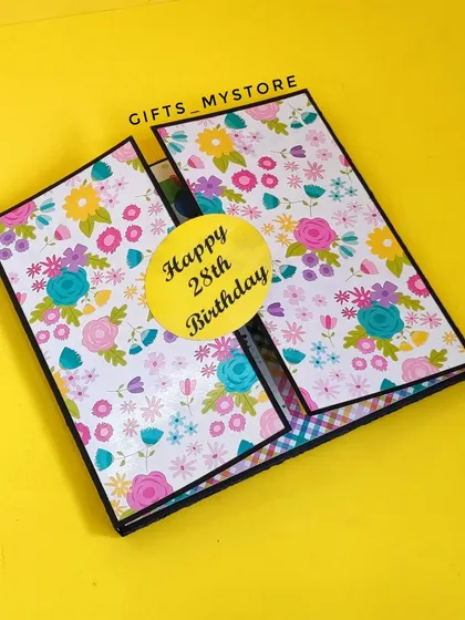 The floral cover of a handmade album, personalized for a 28th birthday.