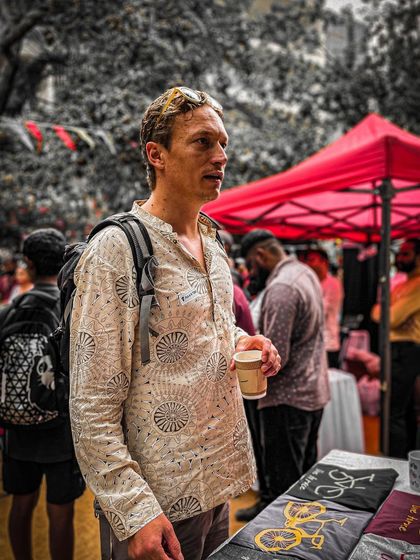 An attendee enjoying a cup of coffee while browsing the stalls at the Garage Sale.