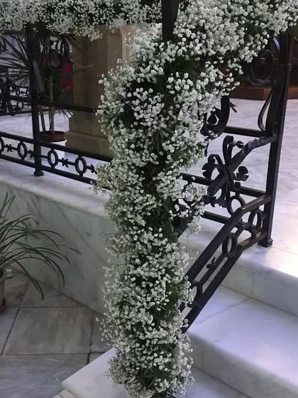 We believe every part of the home can be beautiful. This staircase railing is elegantly wrapped in a garland of delicate baby's breath, adding a touch of grace to the interior.