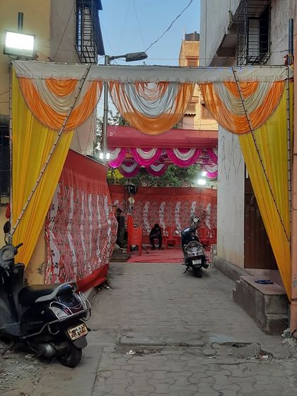 An entrance gate for a Haldi event in a residential lane. The yellow and orange drapes match the festive theme perfectly.