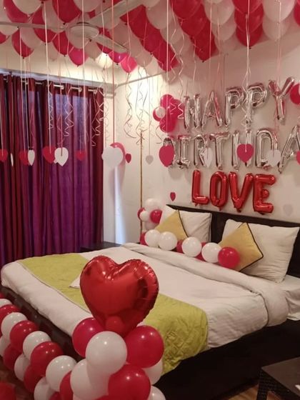 This popular red and white theme is perfect for celebrating a loved one's birthday. The decoration includes "Happy Birthday" and "LOVE" foil balloons, heart-shaped balloon pillars, and balloons covering the ceiling.