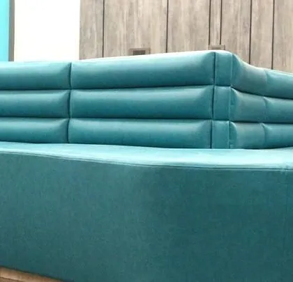 A detail shot of the custom-upholstered waiting area sofa. The channel tufting on the backrest adds a touch of texture and sophistication to the furniture piece.
