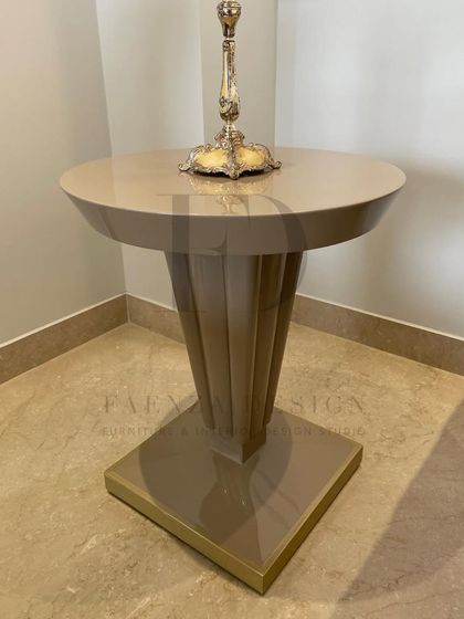 A pair of elegant, high-back lounge chairs in a deep brown fabric. Paired with a sleek, modern side table, they create a sophisticated and comfortable seating area by the window.