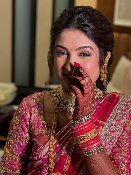 A playful and shy moment captured perfectly. The makeup is designed to look flawless from every angle, with a focus on radiant skin and beautifully defined eyes.