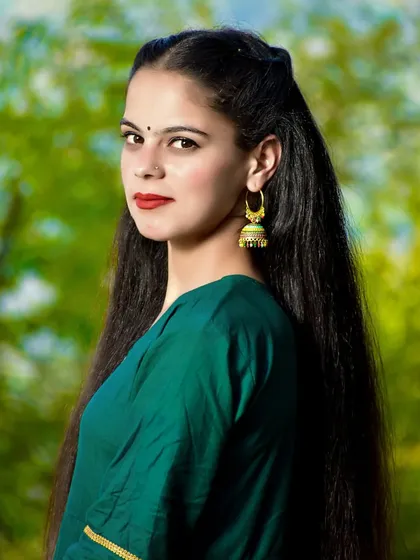 A simple and elegant close-up bridal portrait. The focus here is on her natural beauty and striking features, complemented by traditional jewelry.