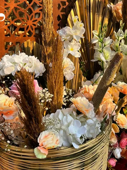 A close-up of a floral arrangement from a boho-themed henna party. The mix of dried pampas grass with soft, pastel-colored fresh flowers creates a beautiful textural contrast that is central to the bohemian aesthetic.