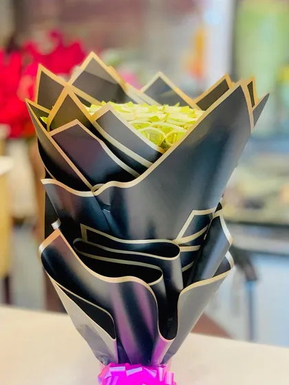 A side view of the currency bouquet, emphasizing the dramatic, layered black wrapping that gives it a modern and luxurious feel.