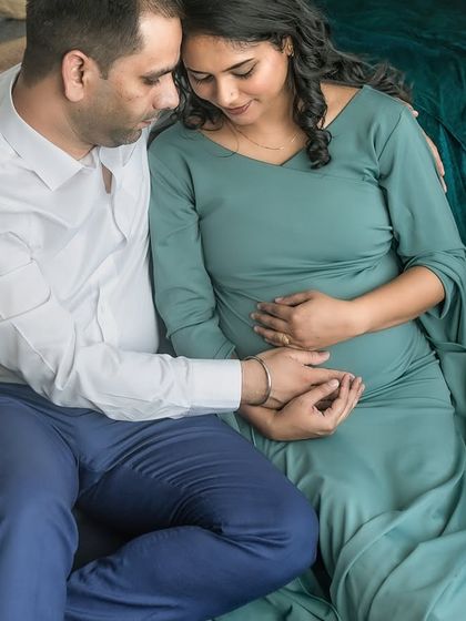 A close, tender moment between the couple, their hands joined over the baby bump. This image is all about the quiet connection and the shared love for their unborn child.