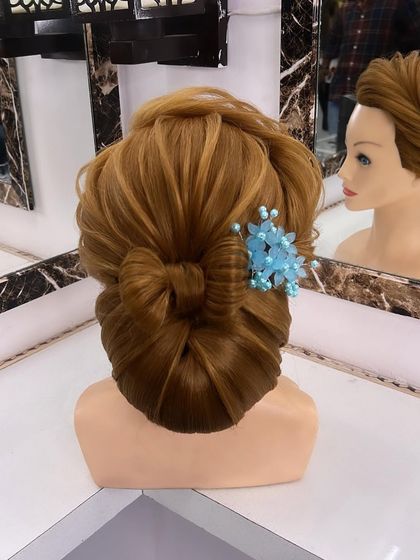 A close-up of the low bun with a bow and a floral accessory.