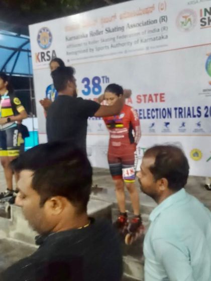 A behind-the-scenes moment from the 38th State Selection Trials, awarding a medal to one of our hardworking skaters on the podium.