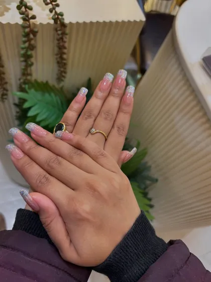 Our glitter French tip extensions, shown on a client. The design is perfect for parties, weddings, or any time you want your nails to shine.