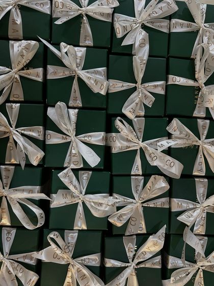 A stunning flat lay of my signature green gift boxes, tied with branded white ribbons, ready for a large corporate or event order.